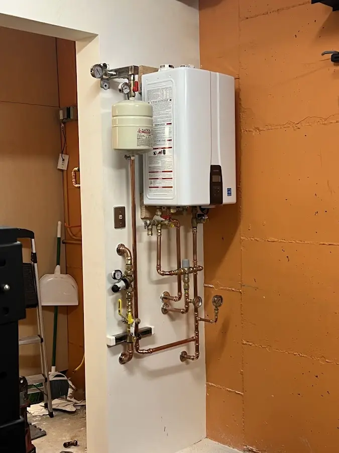 Plumbing technician inspecting water heater connections in Exeter